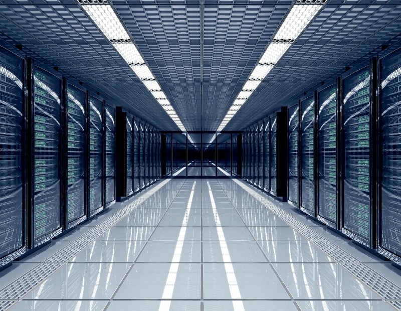 A long hallway lined with rows of servers, showcasing the organized layout of a modern data center. CommercialEdge industrial report
