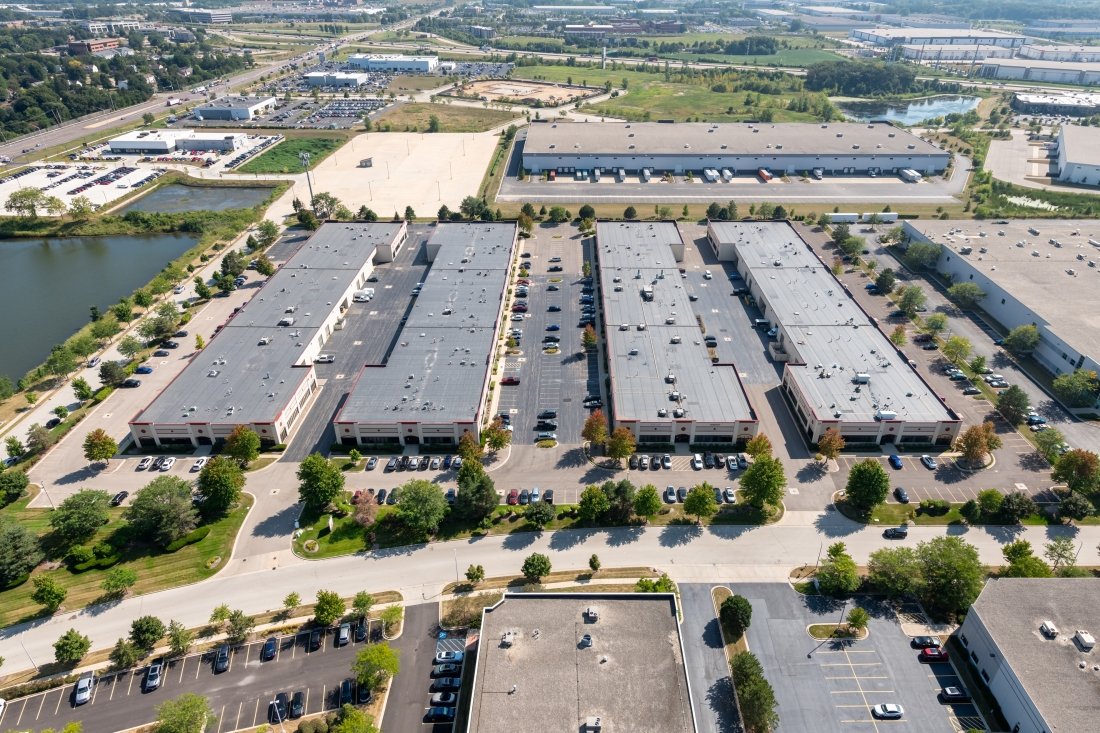 Bird's-eye view of an industrial area with ample parking spaces and multiple industrial structures visible in the scene.