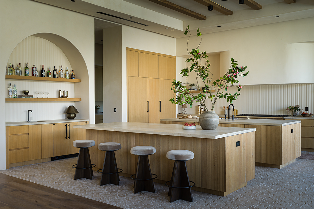 Kitchen with angled view of double islands, oak cabinetry and arched alcove