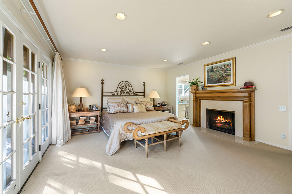 Primary Bedroom with Fireplace | The Agency Journal Primary bedroom with fireplace and French doors