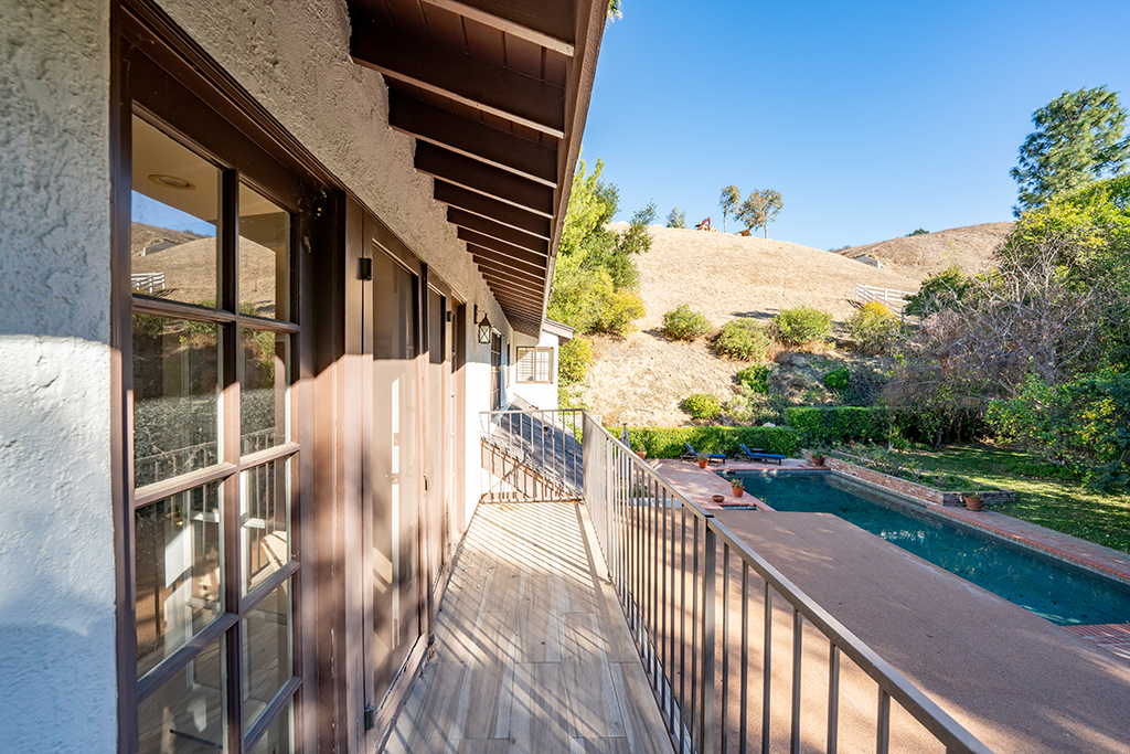 Primary Bedroom Balcony | The Agency Journal Balcony off of primary bedroom overlooking the pool, patio and hillsides
