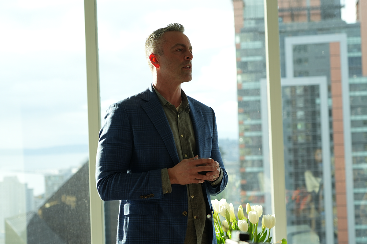 The Agency Art House - Seattle Event; male guest in front of penthouse window overlooking Seattle Skyline