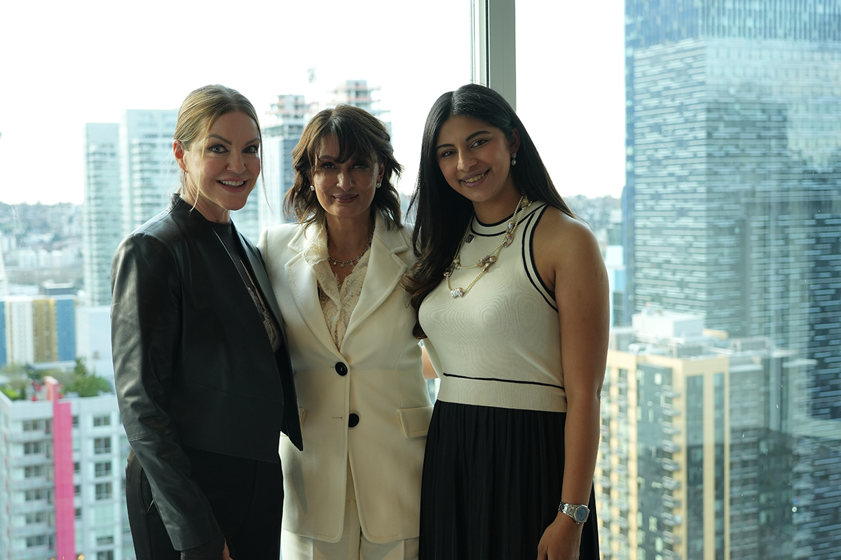 The Agency Art House - Seattle Event- Arushi Kapoor and team pose for photo in front of penthouse windows with Seattle skyline in background