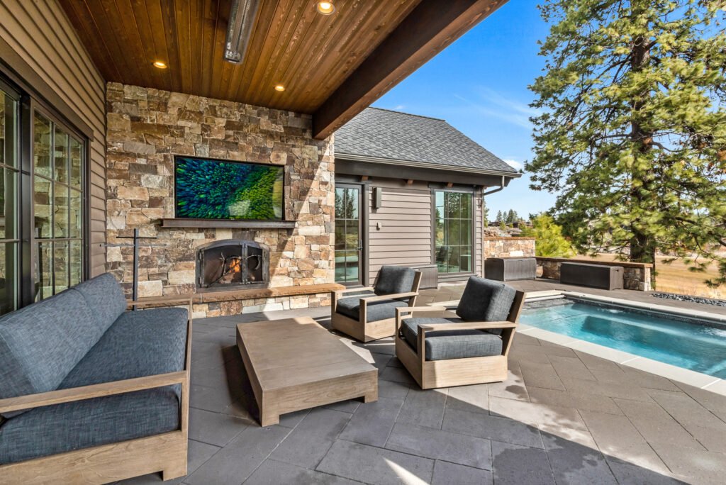 an outdoor living space featuring a patio with a seating area, a fireplace, and a small pool.