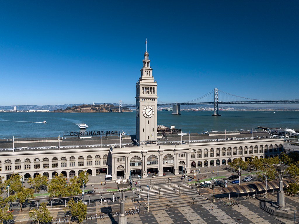 Aerial view of the Ferry Building with the Oakland Bay Bridge in the background