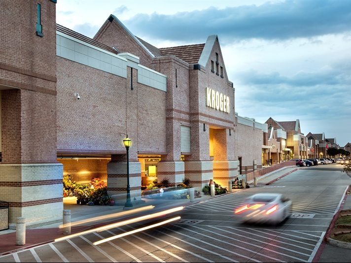 Exterior shot of a road passing by several retail buildings at MacArthur Park