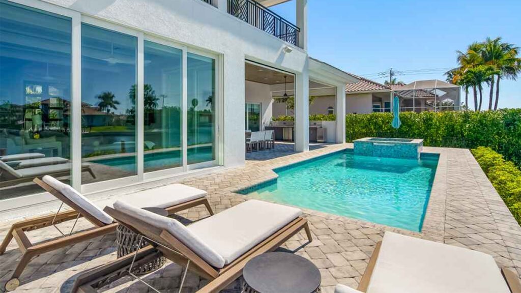 Luxury Florida home with a patio, swimming pool, and lounge chairs