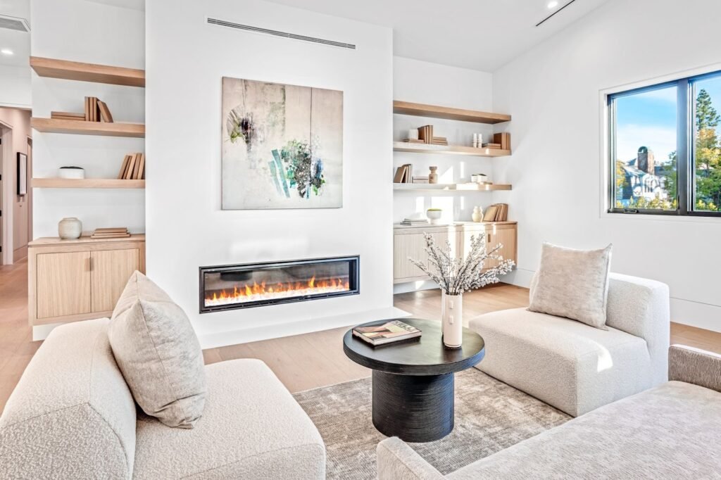Modern minimalist living room with linear fireplace, built-in white oak floating shelves, and neutral furniture