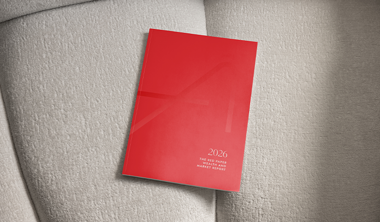 A print copy of The Red Paper on a cream colored sofa