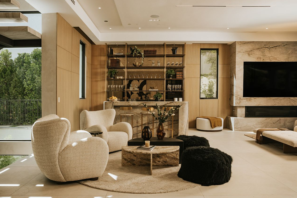 Luxury living space featuring light wood paneling, a marble bar, and an outdoor view.