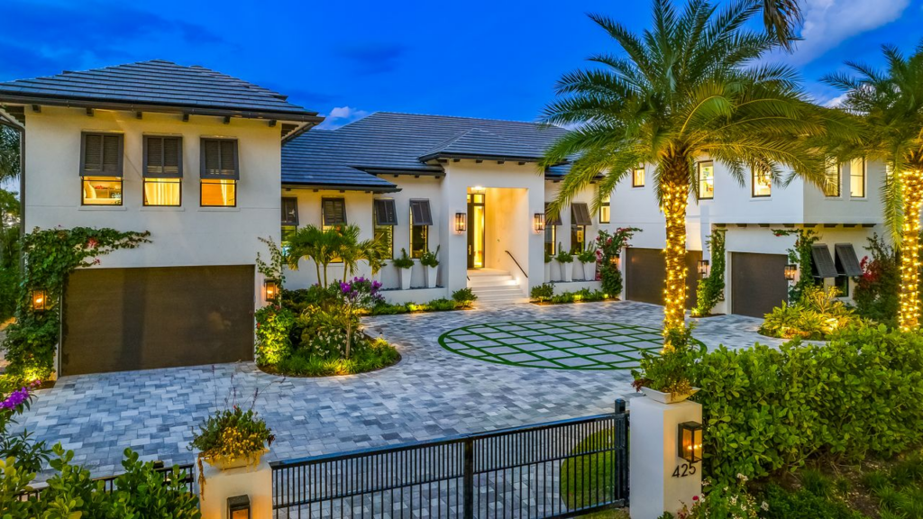 Modern luxury home at 425 15th Ave S Naples FL with paver driveway, three garages, and palm trees