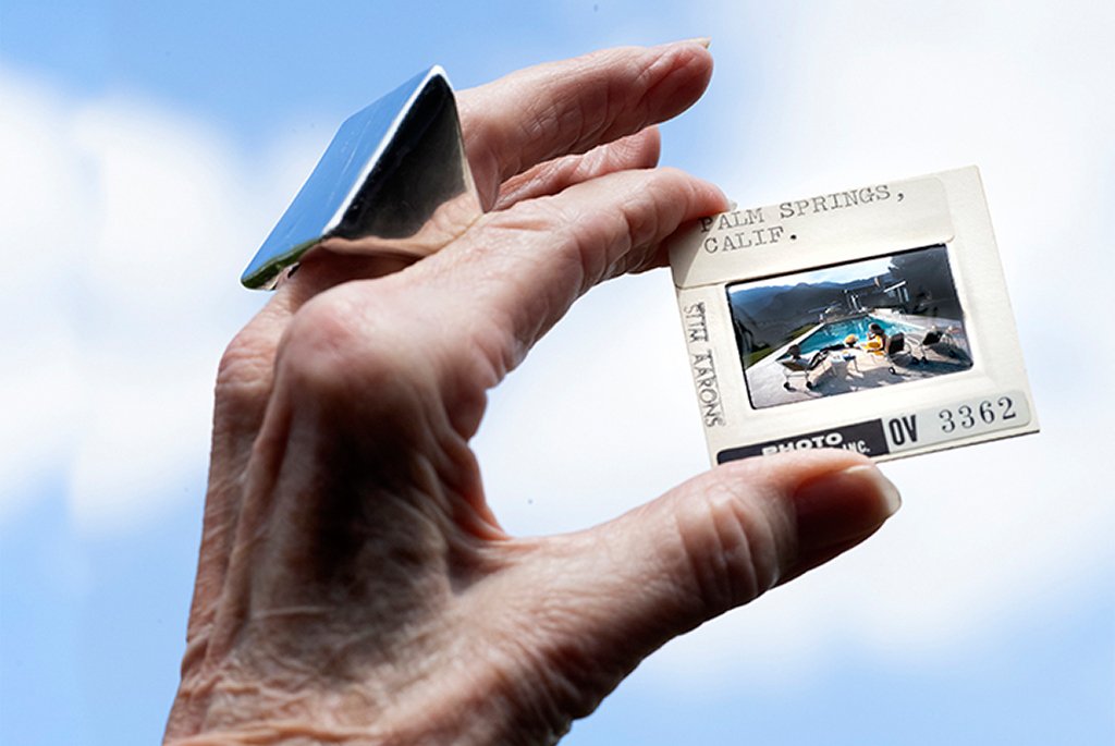 iconic 1970 photograph "Poolside Gossip" by Slim Aarons. The slide mount includes handwritten notes identifying the location as Palm Springs, Calif., the photographer as Slim Aarons, and an archive number OV 3362.