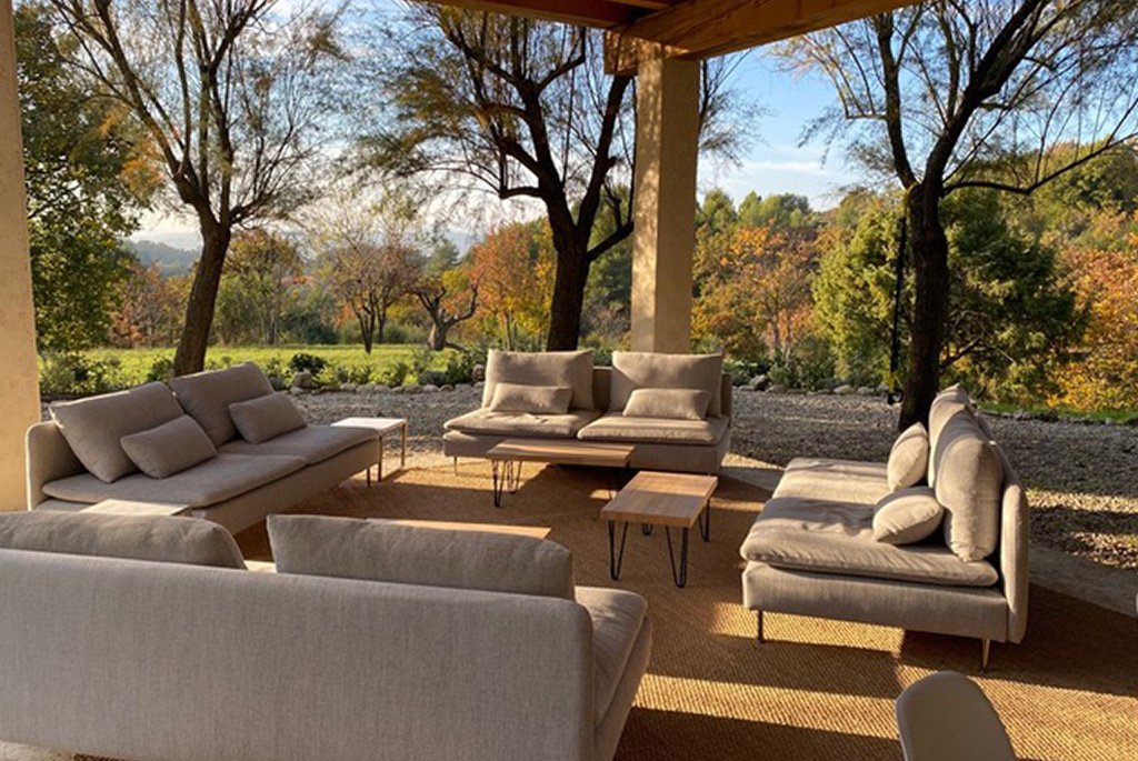 IKEA SÖDERHAMN modular sectional sofas in beige on a sunlit outdoor patio with garden views.