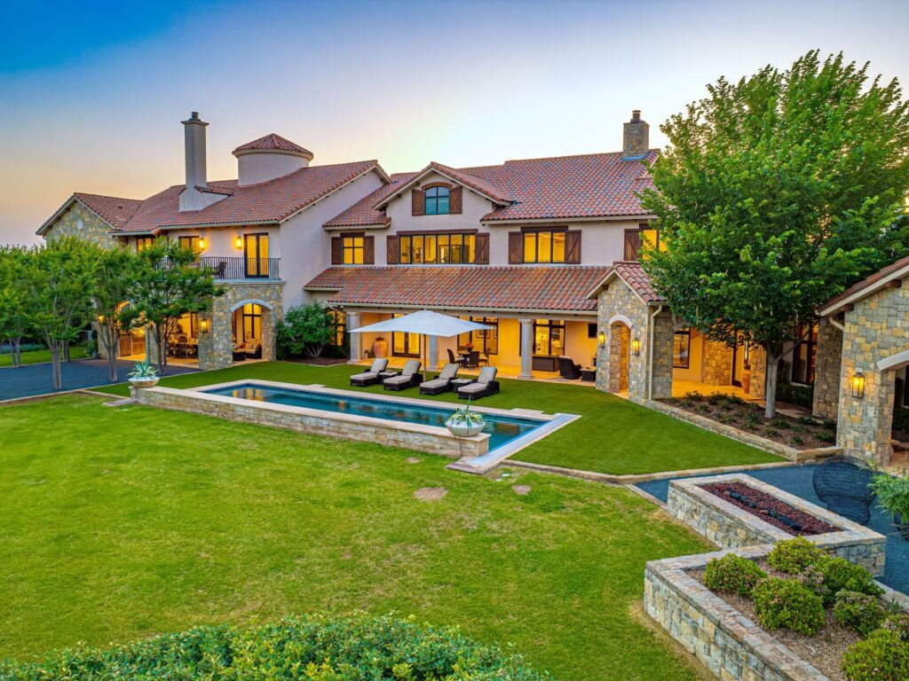 Backyard exterior of the Rick Brown-designed luxury home at 4400 NW 150th St, OKC, featuring a private pool and professional landscaping.