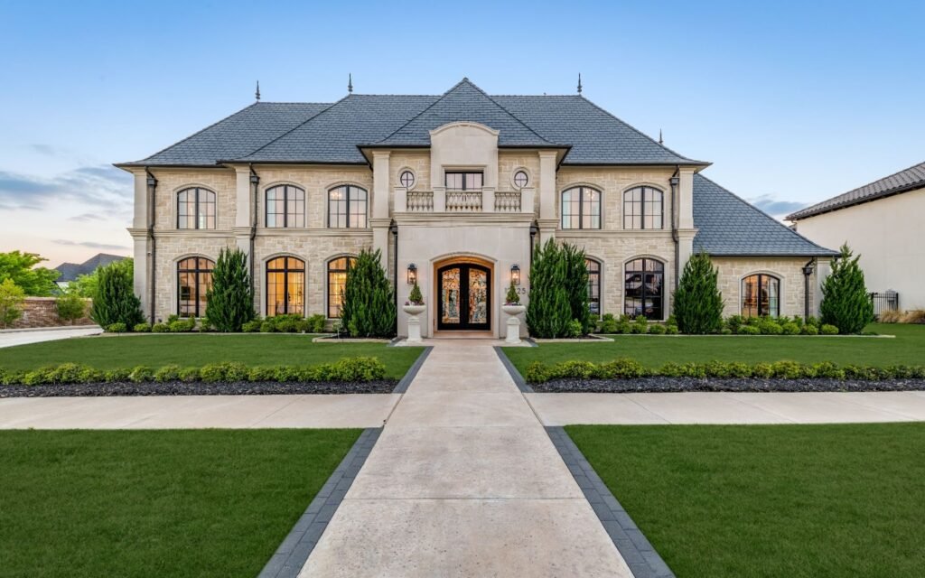Modern French chateau-style luxury home at 12425 Farmstead Dr, Frisco, TX with stone exterior and wrought iron doors.