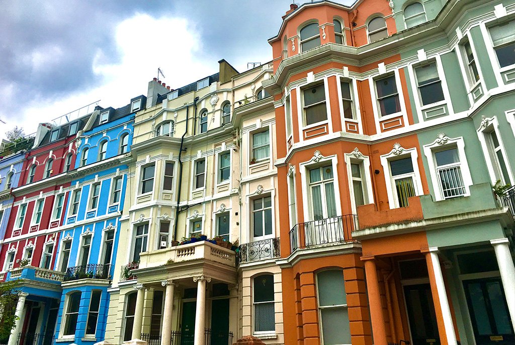 Colorful Victorian townhouses with ornate stucco detailing and classic bay windows.