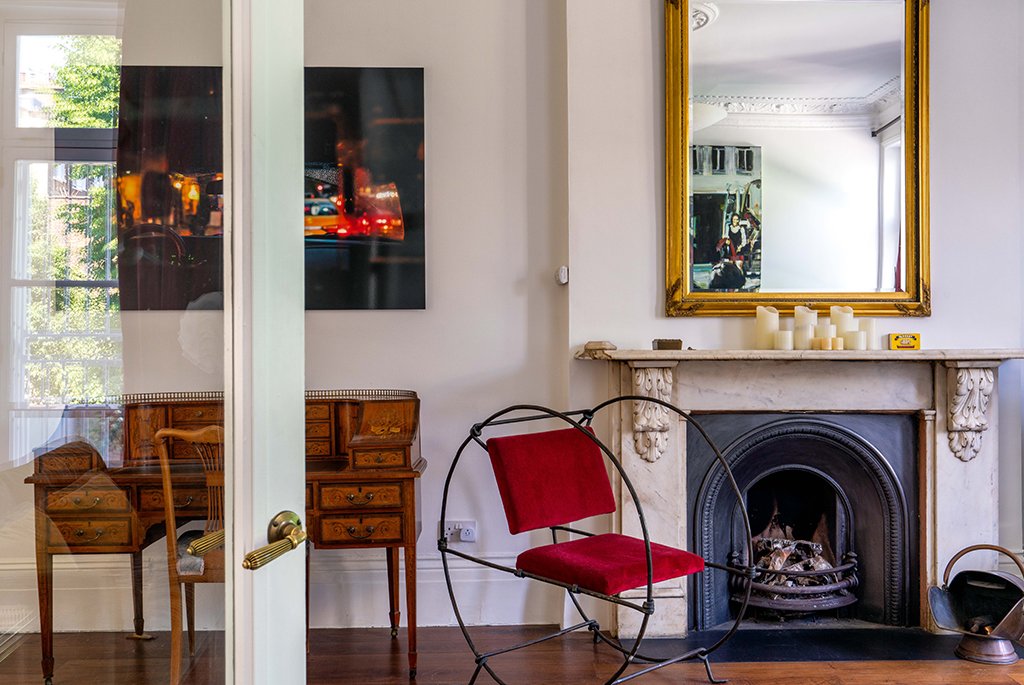 Period home living room featuring an ornate marble fireplace mantel and original crown molding.