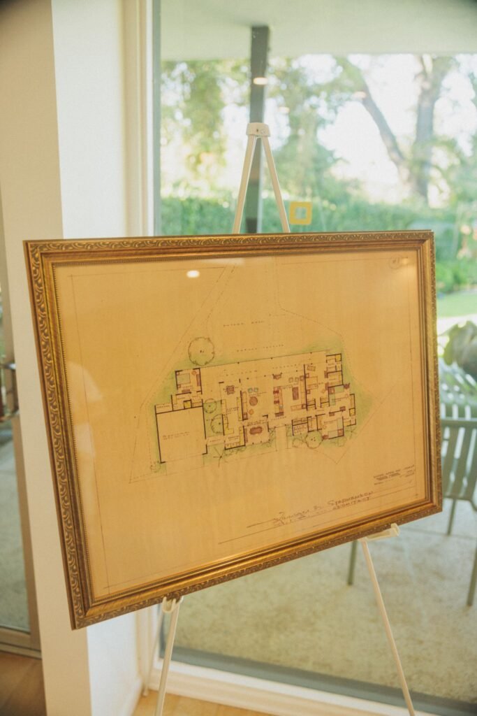 Framed mid-century modern house blueprint on easel display.