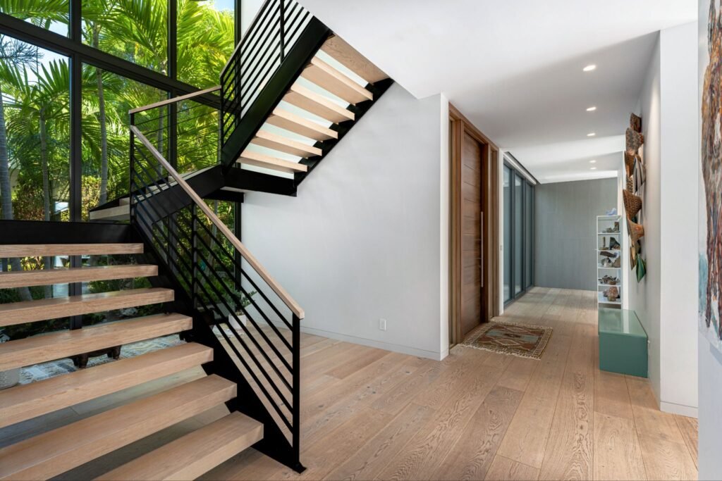 Floating staircase and engineered hardwood flooring in the main living area foyer at 19 Avacado Street, custom-designed by Charles Vincent George Architects in Islamorada.