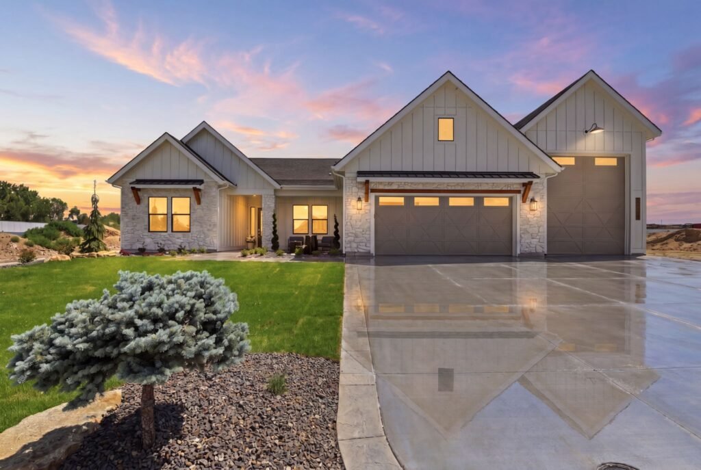 Award-winning modern Spanish Mission ranch house exterior at 7042 E Chicken Hawk Loop in Nampa, Idaho, featuring a massive 50-foot RV bay garage and stone accents at sunset.
