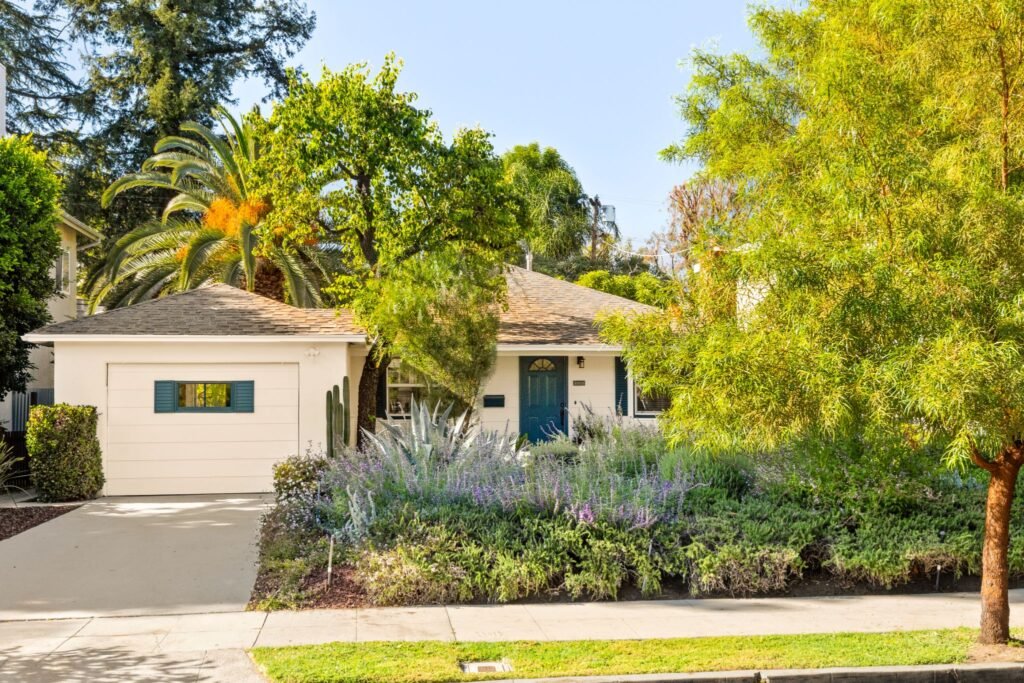 Single-family home exterior with mature native landscaping, a palm tree, and a welcoming front porch at 22051 Celes Street in Woodland Hills, California.