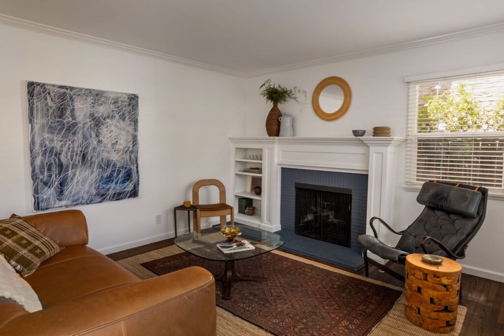 Updated mid-century modern living room with a brick fireplace, leather sofa, and dark hardwood floors at 22051 Celes Street in Woodland Hills, California.