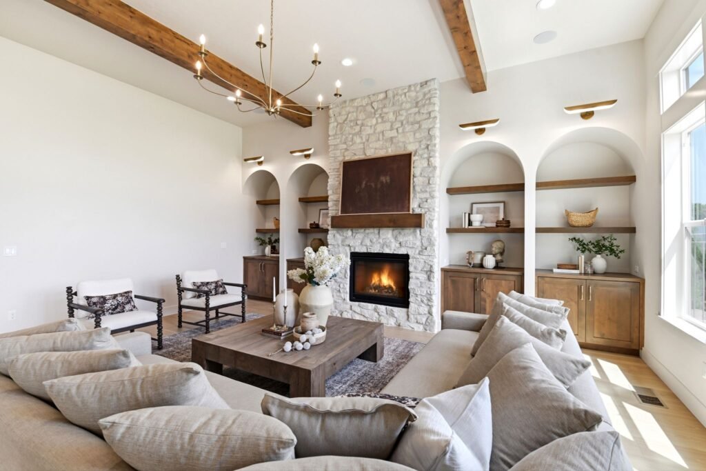 Award-winning Spanish Mission style living room featuring soaring ceilings, exposed wood beams, a stone fireplace, and built-in arched shelving at 7042 E Chicken Hawk Loop in Nampa, Idaho.