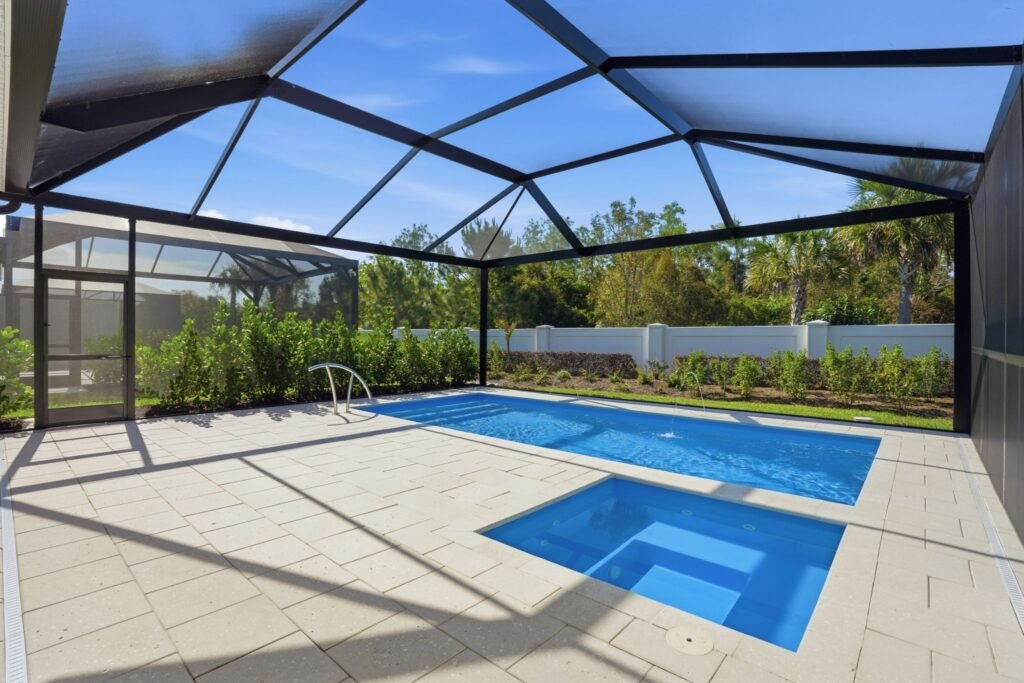 Custom saltwater pool and integrated spa enclosed by a picture-window screened lanai cage at 9194 Cayman Drive in Azure at Hacienda Lakes, Naples, Florida.