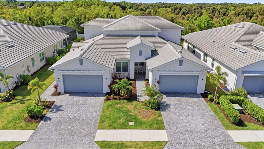 Gated Toll Brothers community attached duplex home exterior with a paved driveway and tile roof at 9194 Cayman Drive in Azure at Hacienda Lakes, Naples, Florida.