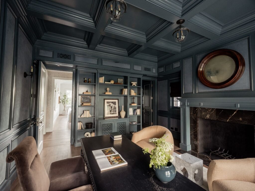 Executive study in a luxury estate showcasing custom millwork, integrated library shelving, plush seating, and premium dark trim details.