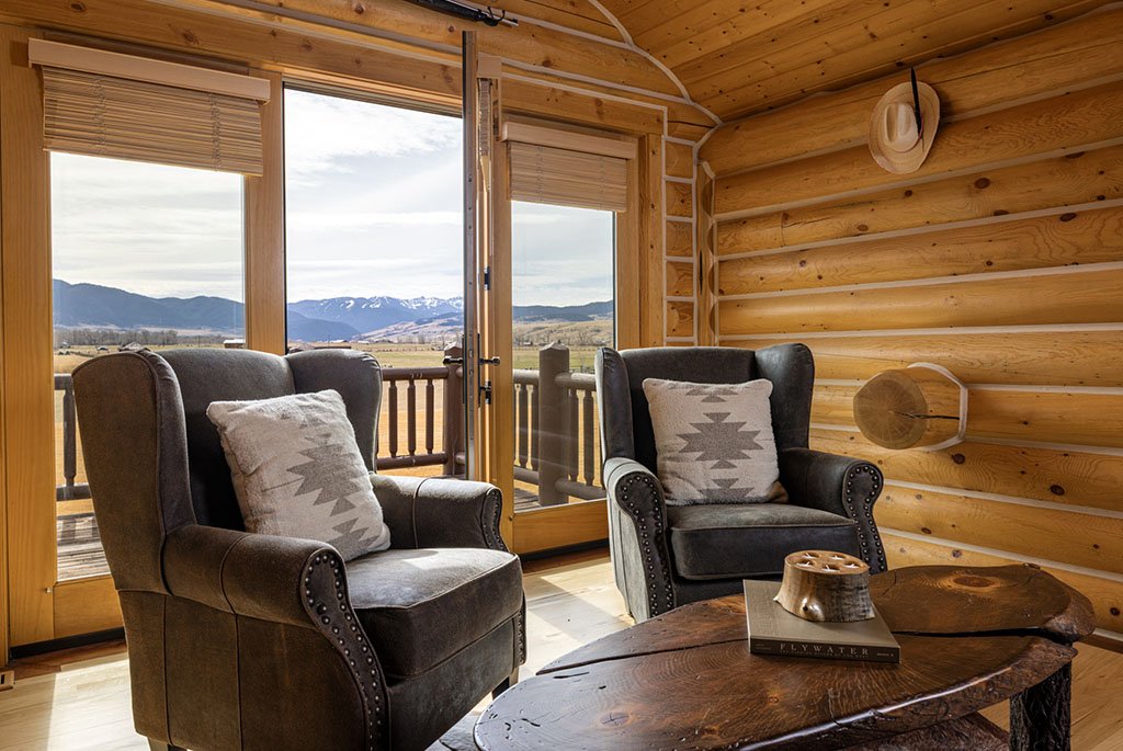 Primary suite sitting area at A River's Ranch opening to a private deck with scenic views of the Montana mountains and pastures.