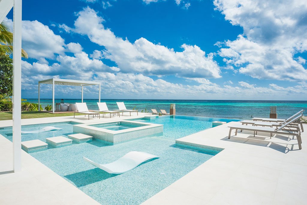 Oceanfront infinity pool and luxury beach deck at Black Urchin Private Beachfront Estate in Grand Cayman.