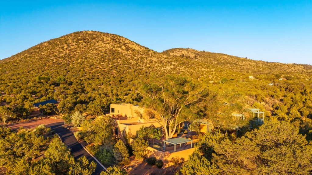 Aerial view of the private adobe estate nestled in the desert hills at 3869 Old Santa Fe Trail in Santa Fe New Mexico.