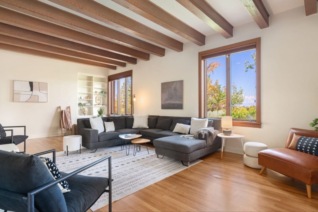 Modern living room with exposed wood vigas and large windows at 3869 Old Santa Fe Trail in Santa Fe New Mexico.