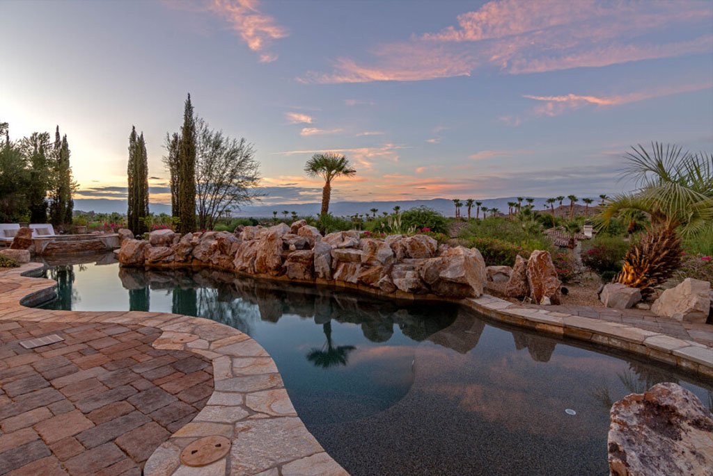 Custom rock waterfall pool at sunset at 49769 Desert Vista Drive in Palm Desert California.