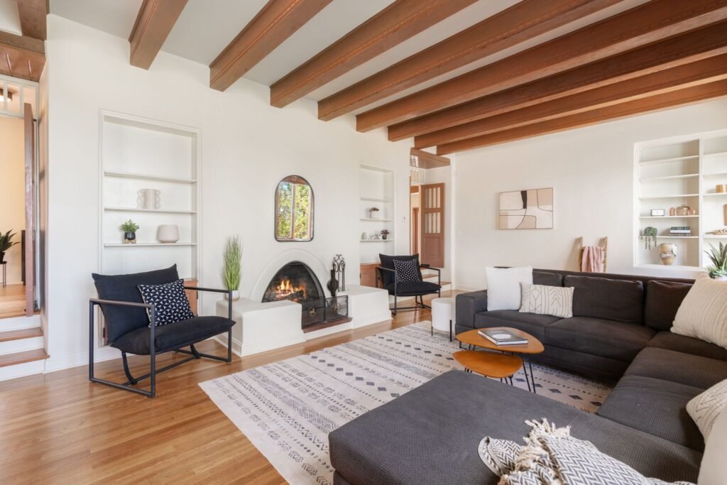 Southwestern living room with a kiva fireplace and exposed ceiling wood beams at 3869 Old Santa Fe Trail in Santa Fe New Mexico.