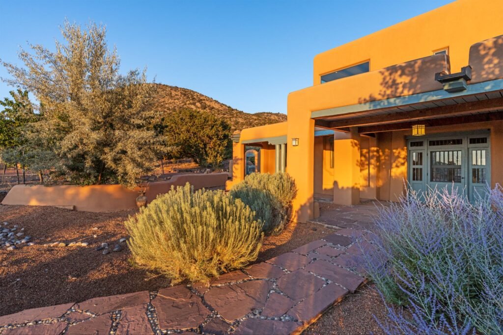 Classic Pueblo revival adobe home exterior and flagstone path at 3869 Old Santa Fe Trail in Santa Fe New Mexico.