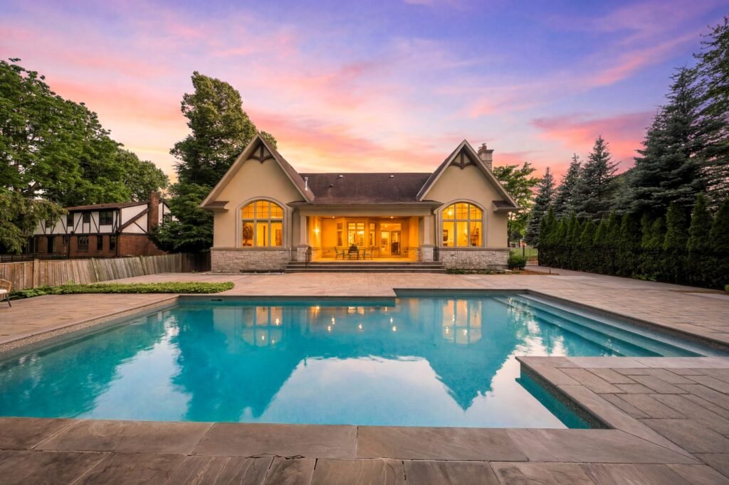Luxury estate backyard pool and covered patio at sunset at 1098 Lakeshore Road in Oakville Ontario.