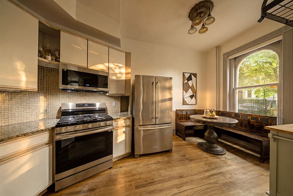 Modern kitchen with stainless steel refrigerator, gas range, and eat-in breakfast booth at 801 Massachusetts Ave NE