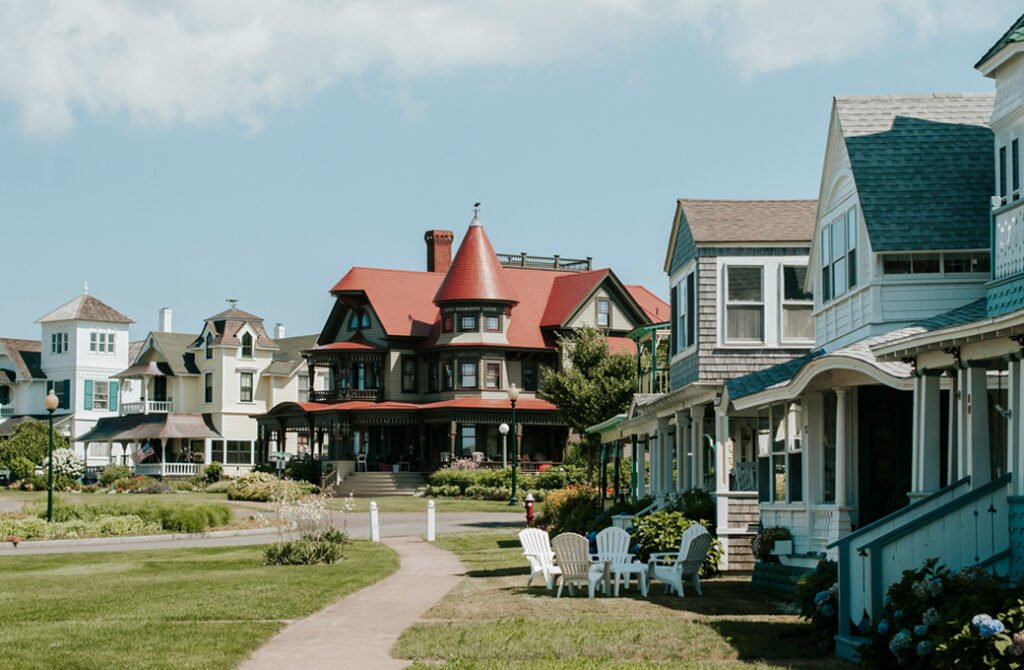 Martha’s Vineyard real estate scene featuring a row of historic seaside estates and cozy coastal cottages surrounding a shared green lawn.