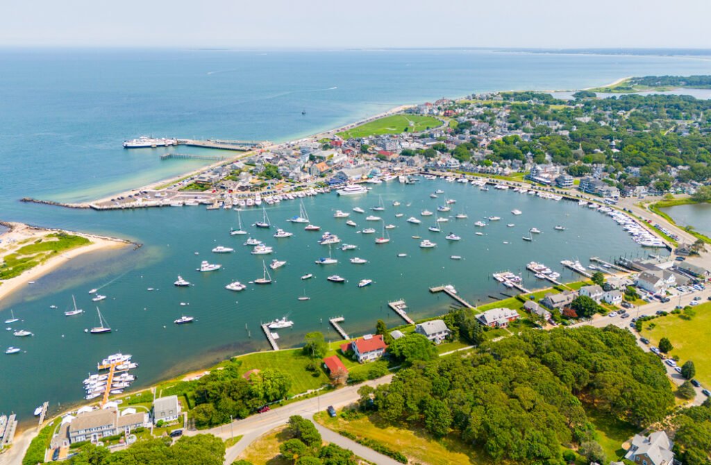 Martha’s Vineyard luxury waterfront real estate overlooking a busy harbor basin packed with sailboats and private motorboats in New England.