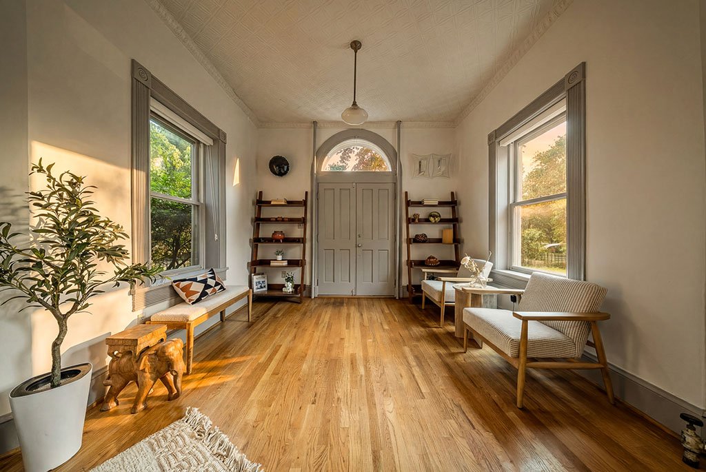 Preserved 1890s Victorian interior foyer with historic window trim, decorative ceiling molding, and modern staging in Capitol Hill Washington DC.