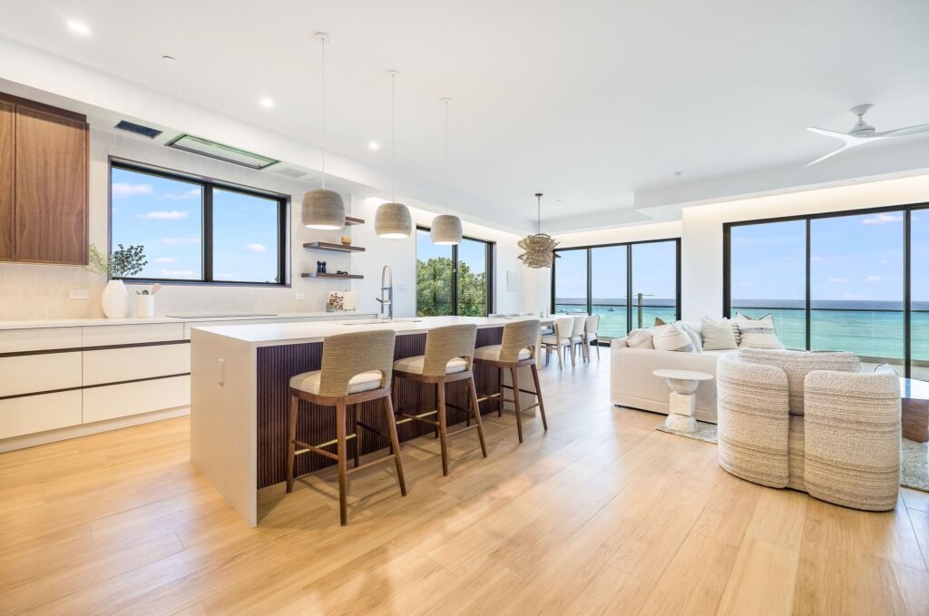The open-concept kitchen and oceanfront living area inside The Sands #2, a luxury condominium on Seven Mile Beach along Boggy Sands Road in the Cayman Islands.