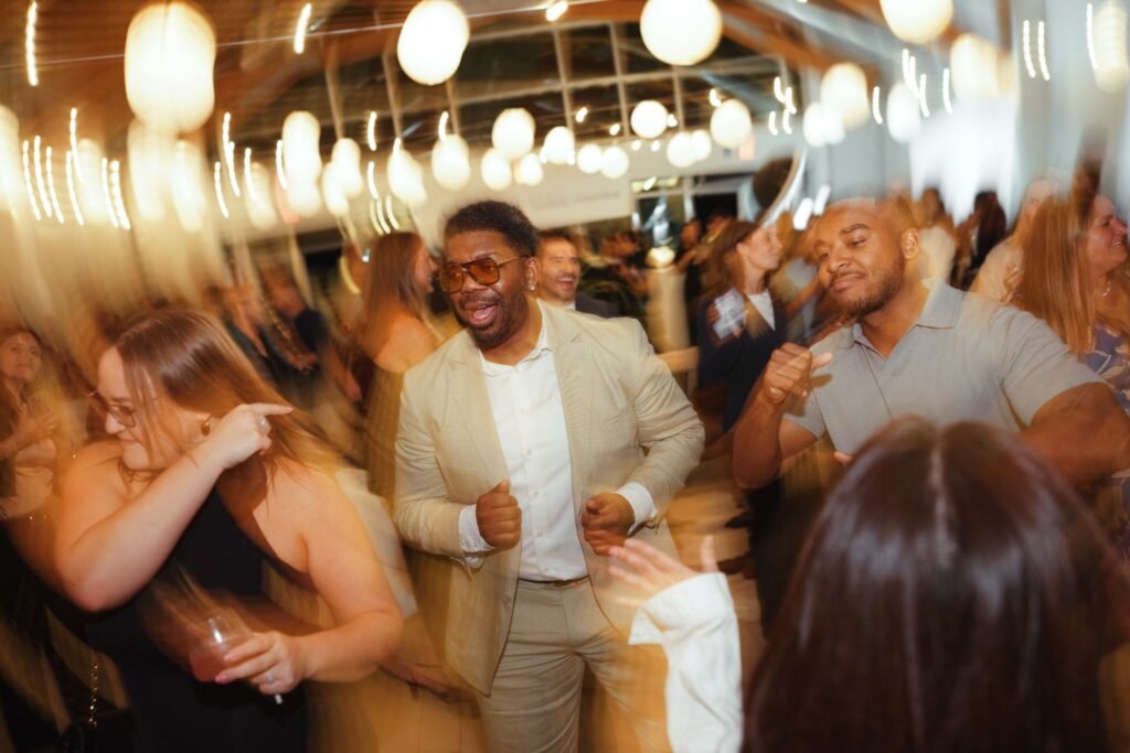 The Agency real estate agent Aken "Moose" Musa dancing with guests on a crowded dance floor during the launch event for The Agency Fairfield.
