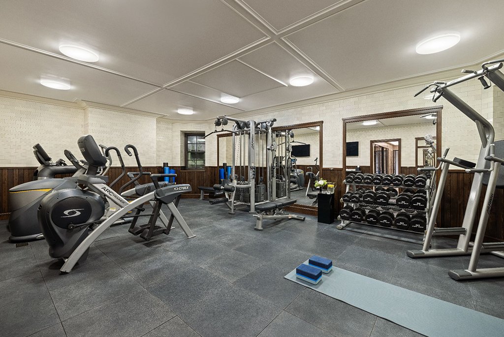 Cellar home gym lined with salvaged virgin chestnut wood and mitered tile at 165 East 70th Street luxury townhouse.