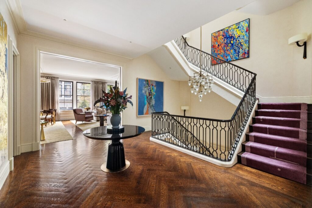 Wrought iron and limestone staircase with quarter-sawn hand-pillowed oak floors at 165 East 70th Street luxury townhouse foyer.
