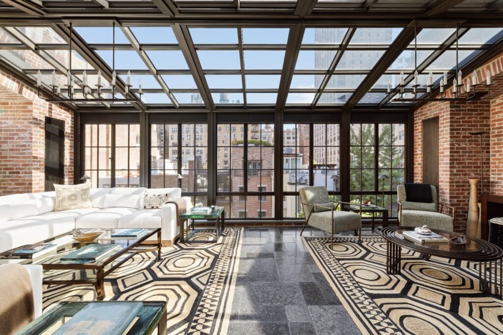 Fifth-floor glass-paneled solarium with exposed brick, glass ceiling, and Upper East Side skyline views at 165 East 70th Street.