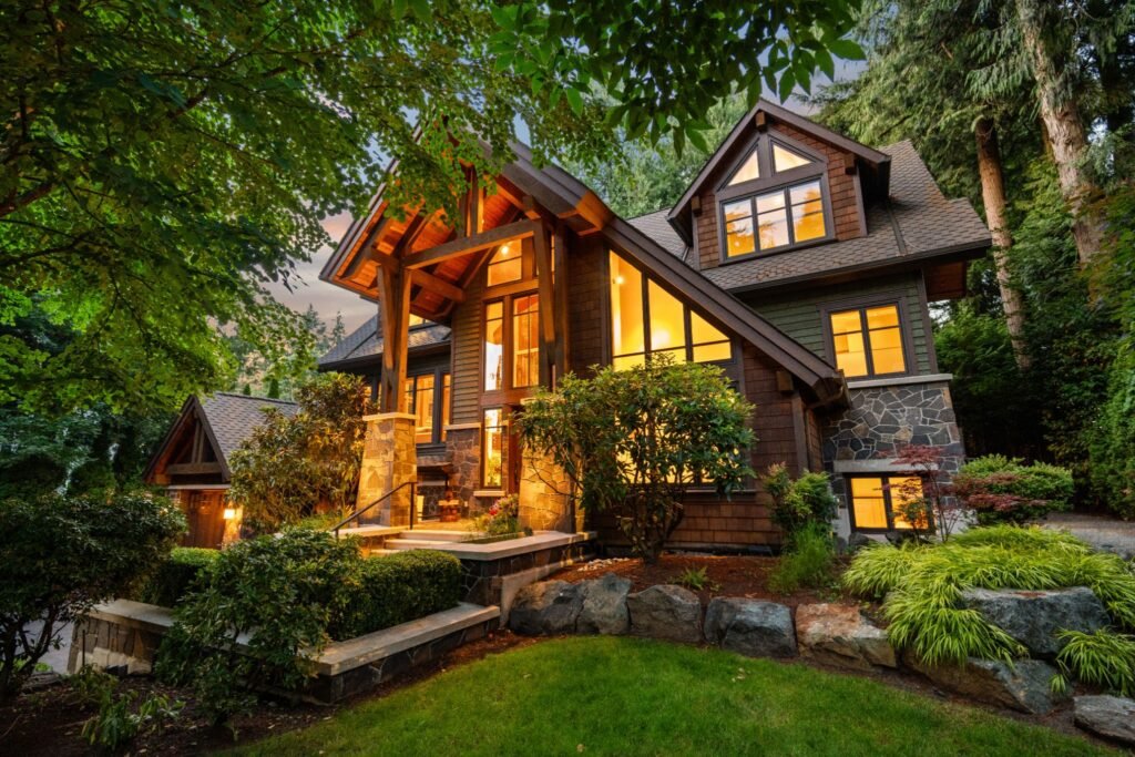 The exterior front facade of 2650 Dogwood Drive, a luxury timber-frame home nestled in trees near Crescent Beach, British Columbia, beautifully illuminated at dusk