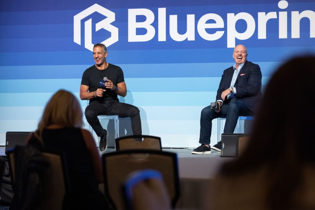 Mauricio Umansky and Tom Bohn sharing a laugh during a luxury real estate panel at the Blueprint conference in Las Vegas.